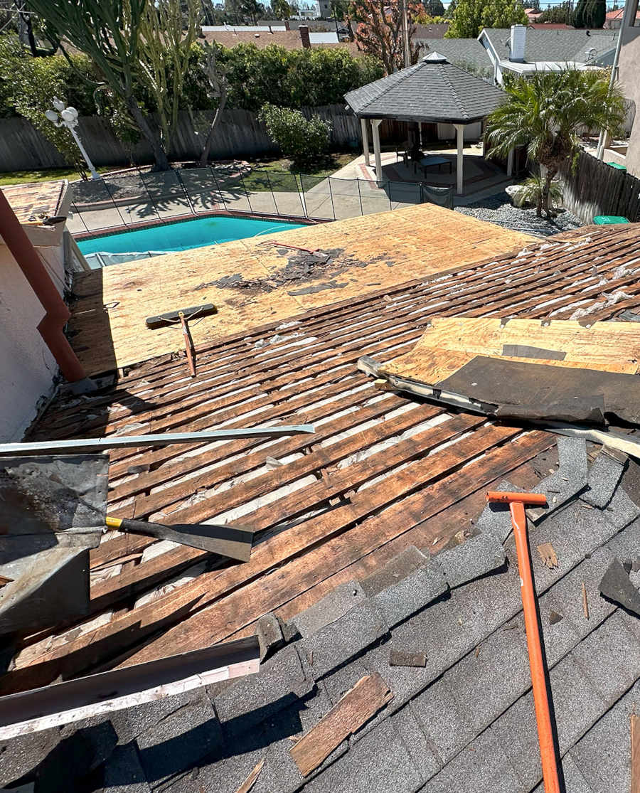 A roof under renovation, revealing wooden beams and underlayment.